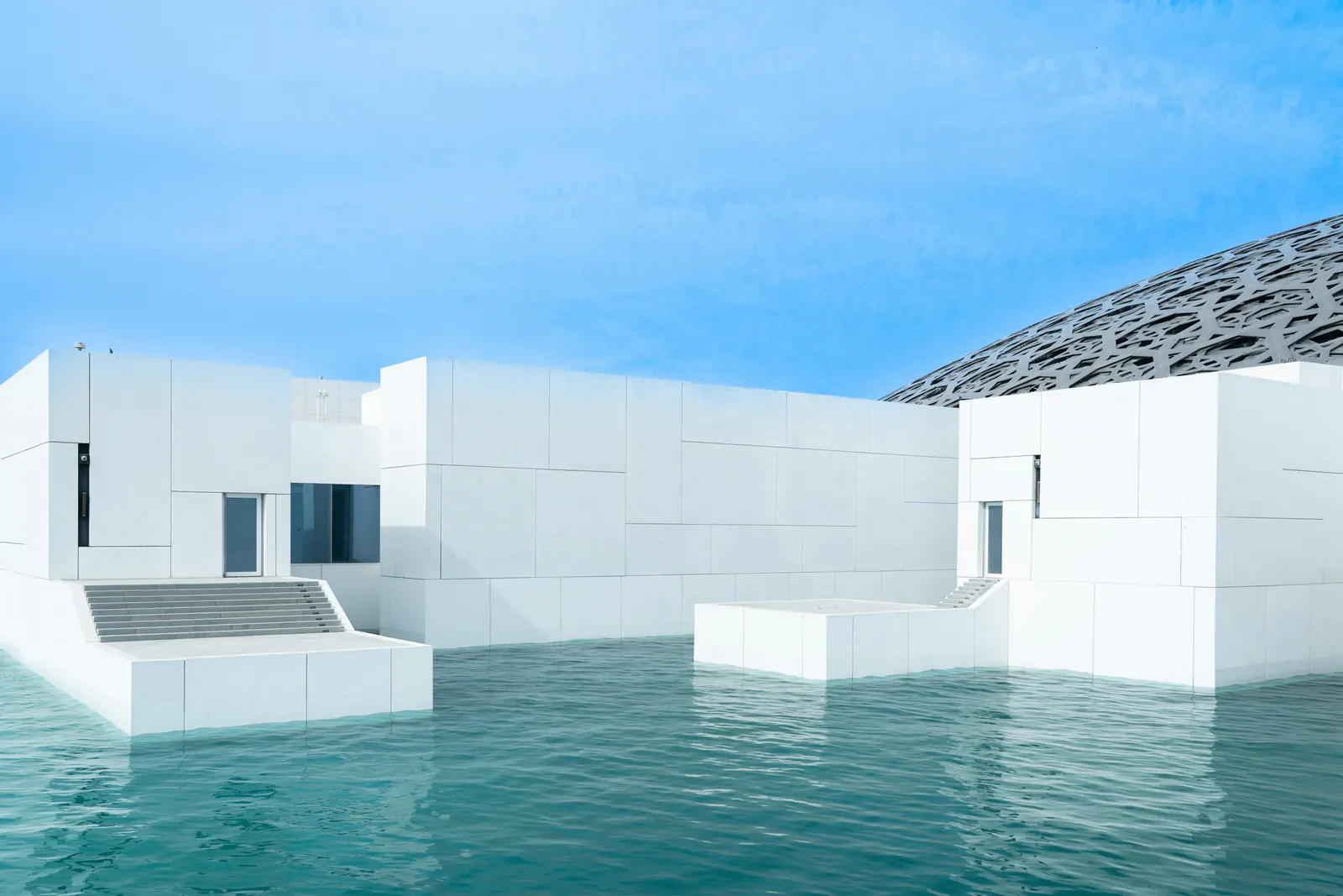Geometric architecture beside the water at the Louvre Abu Dhabi